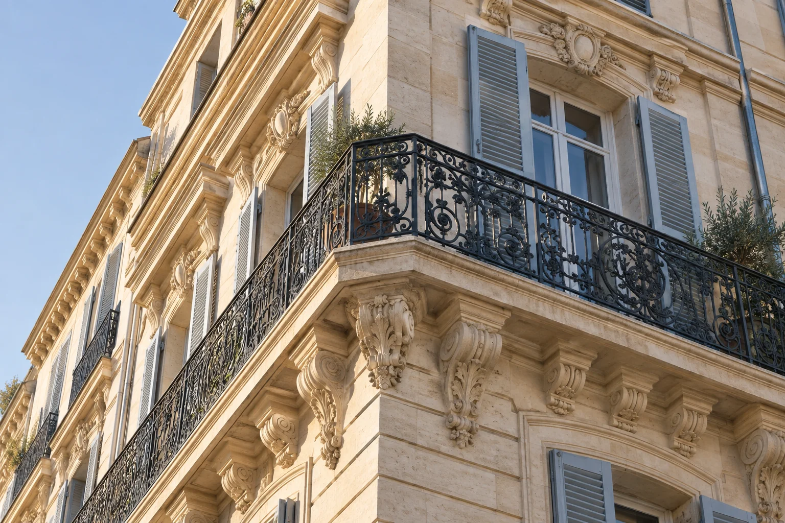Illustration d’un balcon en ferronnerie et de détails sculptés sur une façade marseillaise
